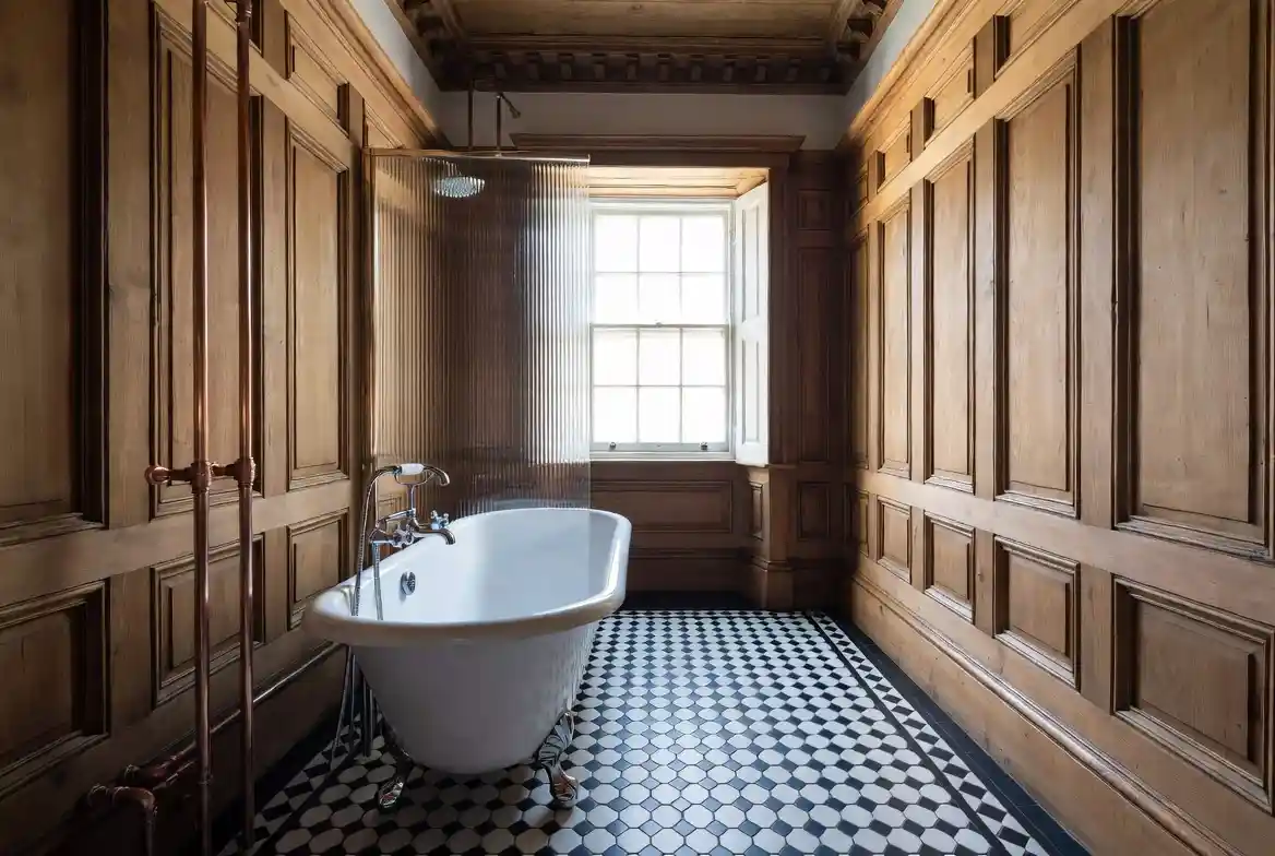Period bathroom with roll-top cast iron bath, monochrome geometric tiles and panelled timber walls in Tunbridge Wells, Kent